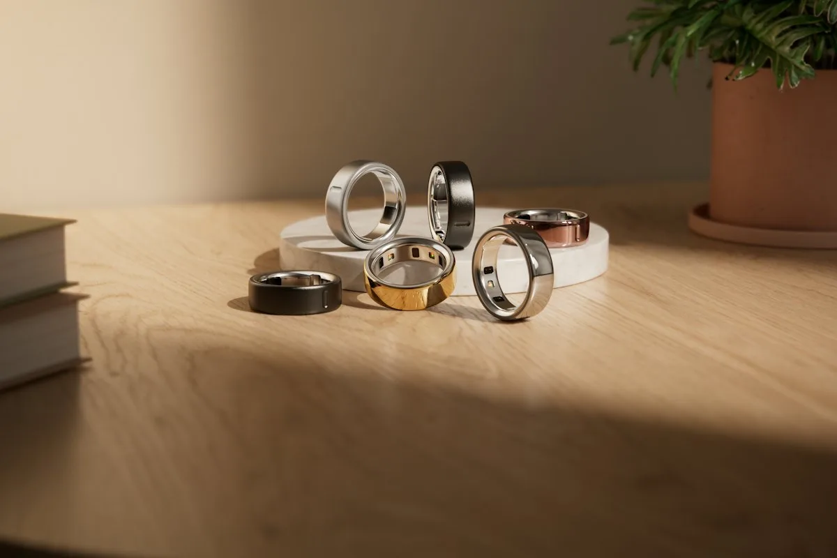 Plusieurs bagues connectées Oura en différentes finitions posées sur une table